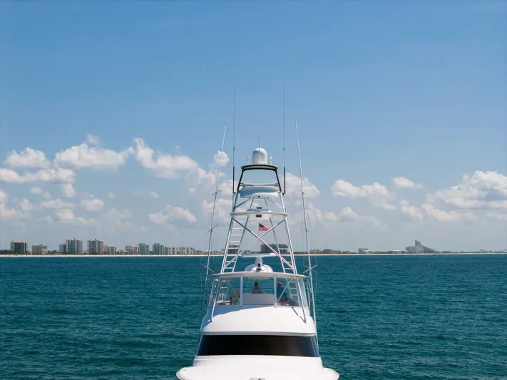 Da'grits Yacht Photos Pics 2018 Viking 62 Convertible yacht cruising on open water with city skyline in background.