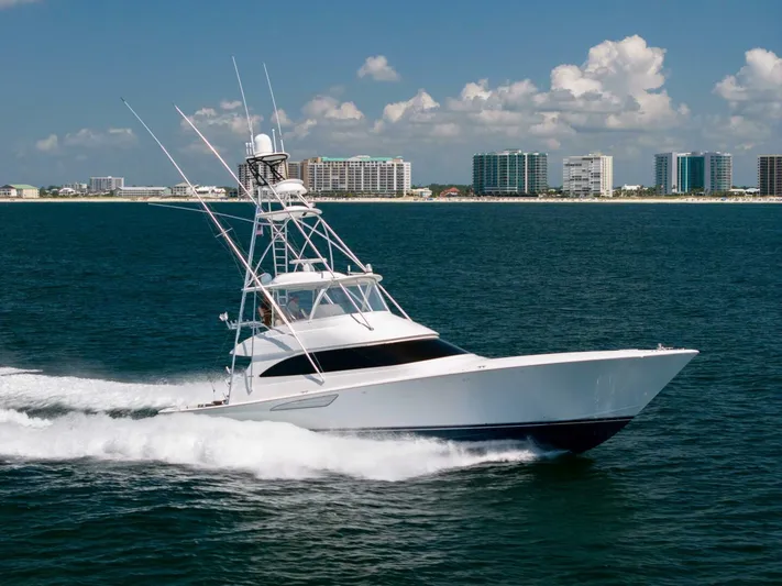 Da'grits Yacht Photos Pics 2018 Viking 62 Convertible yacht cruising on ocean near city skyline.