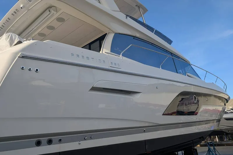  Yacht Photos Pics 2022 Prestige 590 yacht with sleek design and modern features, docked under clear blue sky.