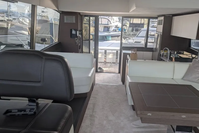  Yacht Photos Pics Luxurious interior of 2022 Prestige 590 yacht with modern seating and kitchen area.