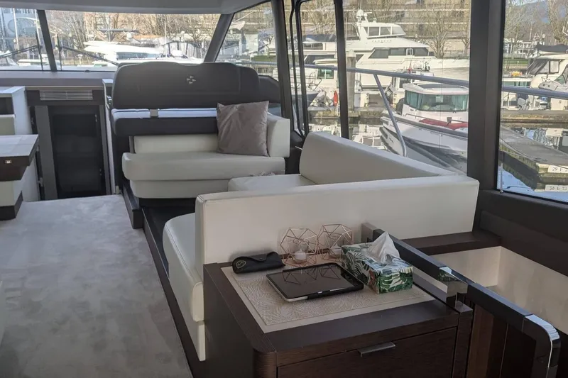  Yacht Photos Pics Luxurious interior of 2022 Prestige 590 yacht with elegant seating and marina view.