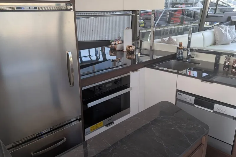  Yacht Photos Pics Modern kitchen interior on 2022 Prestige 590 yacht with sleek appliances and elegant design.