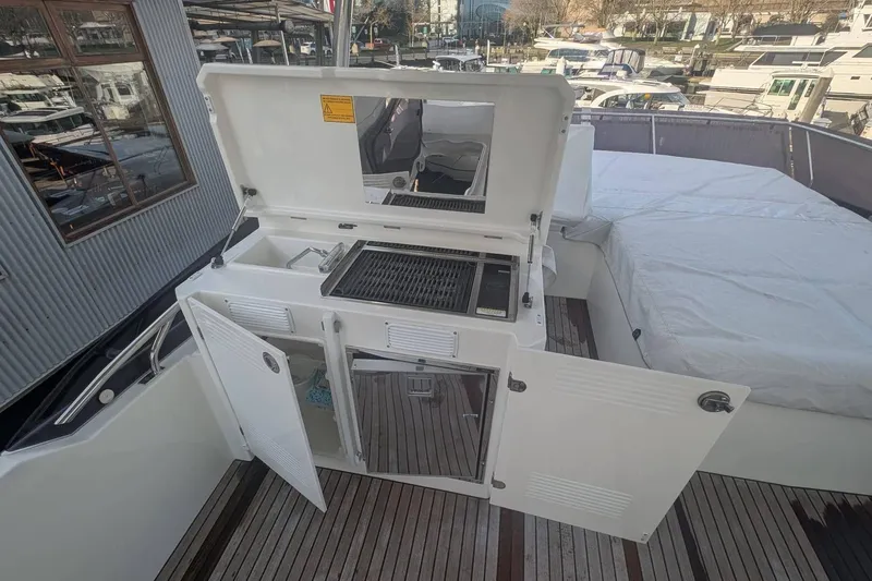  Yacht Photos Pics Outdoor kitchen on 2022 Prestige 590 yacht with grill and storage compartments.