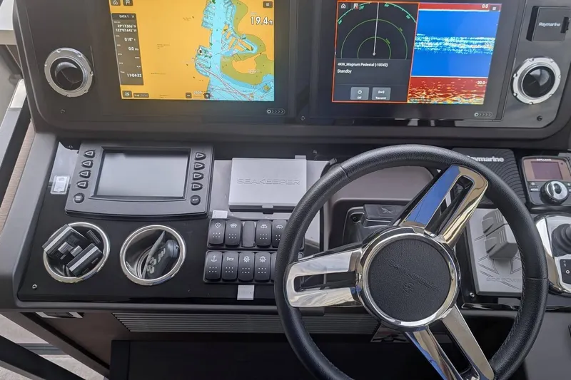  Yacht Photos Pics Cockpit of 2022 Prestige 590 yacht with navigation screens and steering wheel.