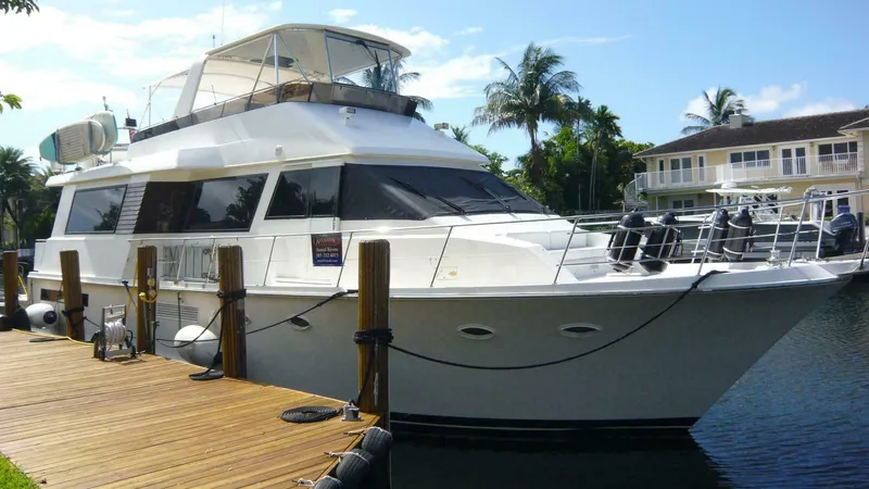 Vitamin Sea Yacht Photos Pics 1990 Viking Cockpit Motor Yacht docked by waterfront homes, under clear blue sky.