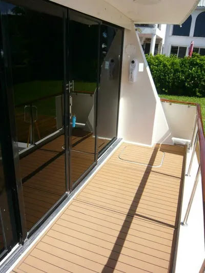 Vitamin Sea Yacht Photos Pics 1990 Viking Cockpit Motor Yacht deck with glass doors and wooden flooring.