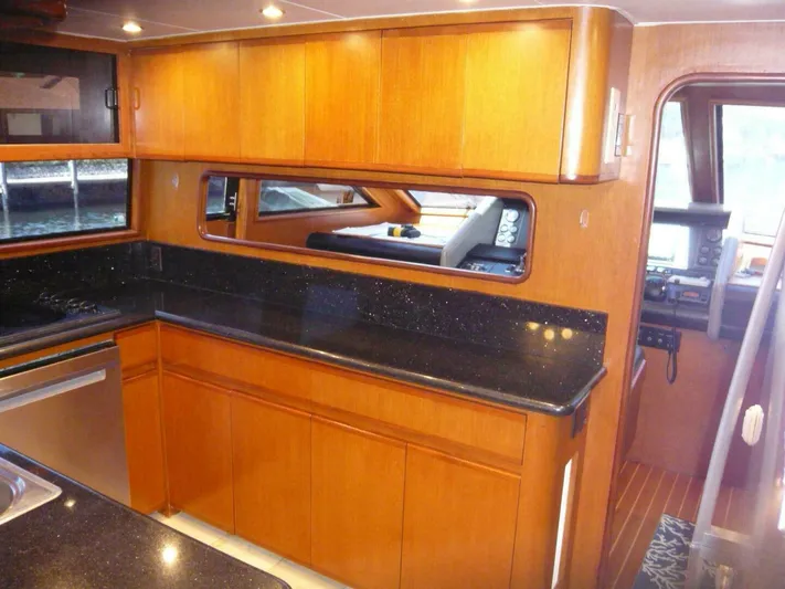 Vitamin Sea Yacht Photos Pics Luxurious 1990 Viking Cockpit Motor Yacht interior with sleek wooden cabinetry and modern appliances.