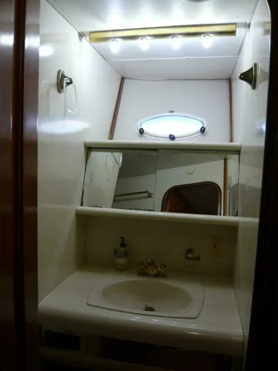 Vitamin Sea Yacht Photos Pics 1990 Viking Cockpit Motor Yacht bathroom with sink, mirror, and lighting.