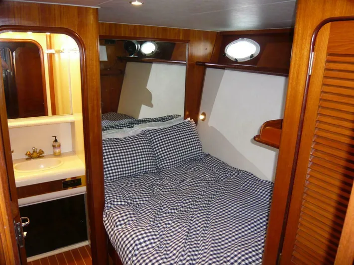 Vitamin Sea Yacht Photos Pics Cozy cabin interior of 1990 Viking Cockpit Motor Yacht with checkered bedding and wooden accents.