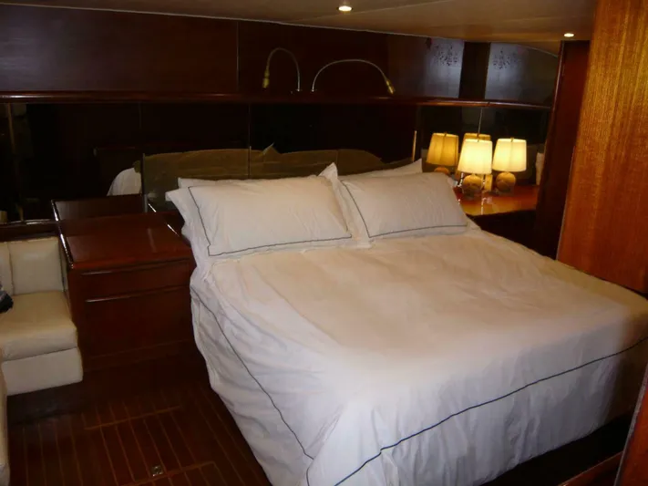 Vitamin Sea Yacht Photos Pics Luxurious bedroom interior of 1990 Viking Cockpit Motor Yacht with elegant bedding and warm lighting.