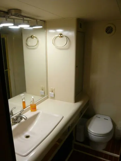 Vitamin Sea Yacht Photos Pics Bathroom interior of a 1990 Viking Cockpit Motor Yacht, featuring a sink and toilet.