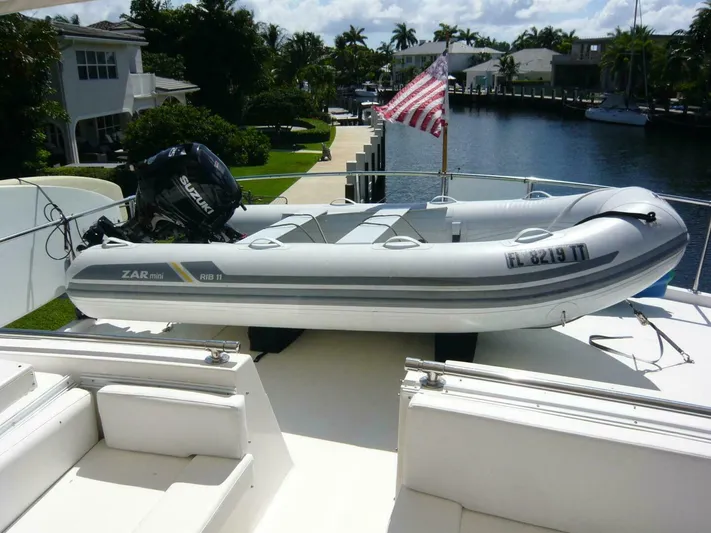Vitamin Sea Yacht Photos Pics Inflatable boat on 1990 Viking Cockpit Motor Yacht, docked by a canal with American flag.