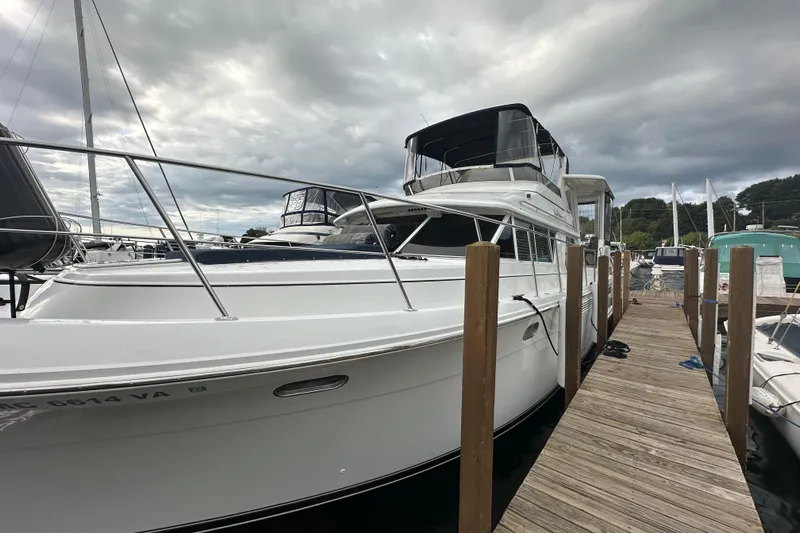  Yacht Photos Pics 1998 Carver 445 Aft Cabin Motor Yacht docked at marina under cloudy sky.