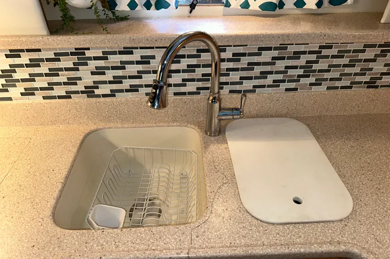  Yacht Photos Pics Modern kitchen sink with chrome faucet and cutting board on Carver 445 Aft Cabin Motor Yacht.