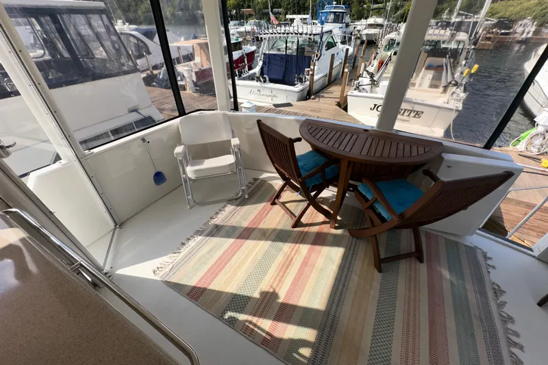  Yacht Photos Pics 1998 Carver 445 Aft Cabin Motor Yacht interior with seating and table on deck.