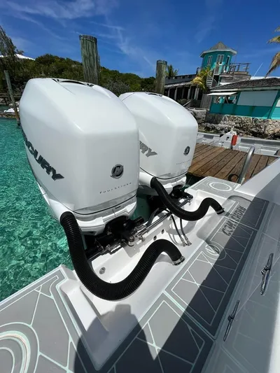  Yacht Photos Pics 2016 Contender 28 Sport boat with twin outboard motors docked by turquoise water.