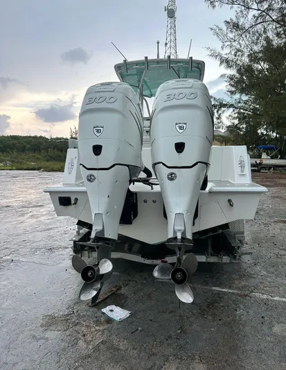  Yacht Photos Pics 2016 Contender 28 Sport boat with twin 300 horsepower engines, docked on a wet surface.