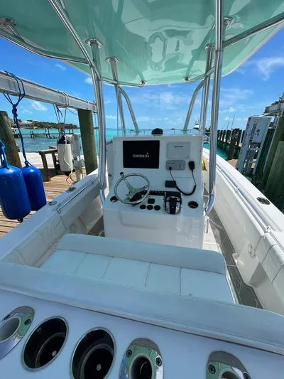  Yacht Photos Pics 2016 Contender 28 Sport boat with modern console, docked by clear blue water.
