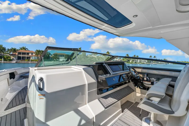  Yacht Photos Pics 2020 Sea Ray 400 SLX Outboard helm with luxurious seating and modern controls, overlooking waterfront homes.