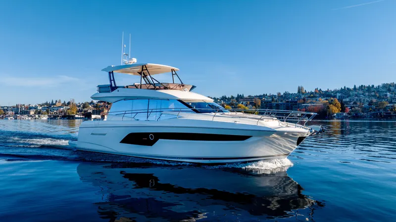  Yacht Photos Pics Luxury 2023 Prestige 520 yacht cruising on a serene lake under clear blue skies.