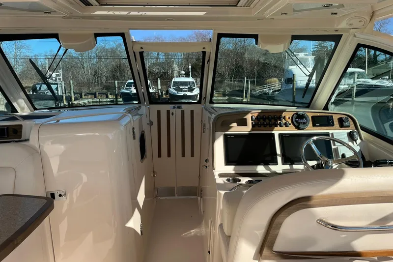  Yacht Photos Pics 2015 Grady-White Freedom 375 boat interior with helm, steering wheel, and navigation screens.