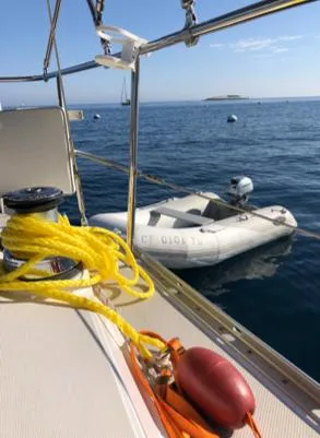 Nina Mia Yacht Photos Pics Catalina 385 sailboat deck with yellow rope, inflatable dinghy, and ocean view.