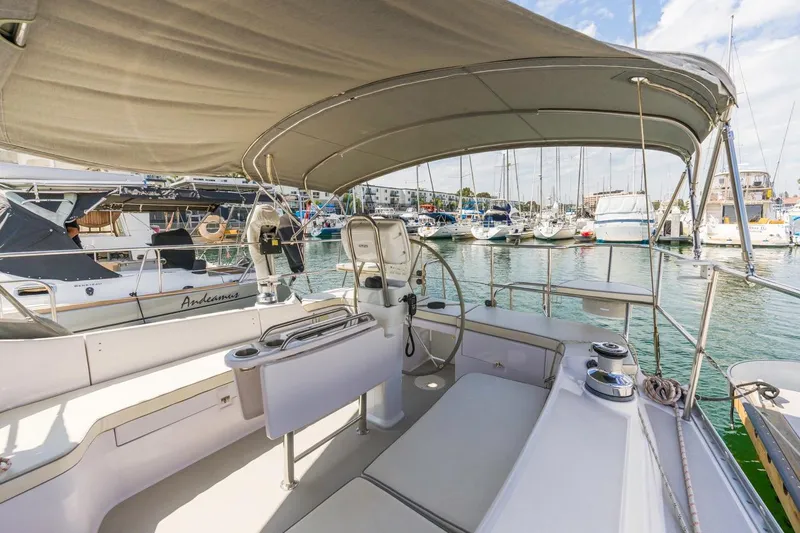 Nina Mia Yacht Photos Pics 2018 Catalina 385 sailboat cockpit with canopy, docked in a marina with other boats.