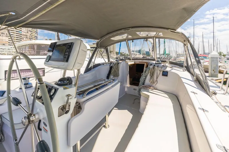 Nina Mia Yacht Photos Pics 2018 Catalina 385 sailboat cockpit with steering wheel, navigation equipment, and marina view.