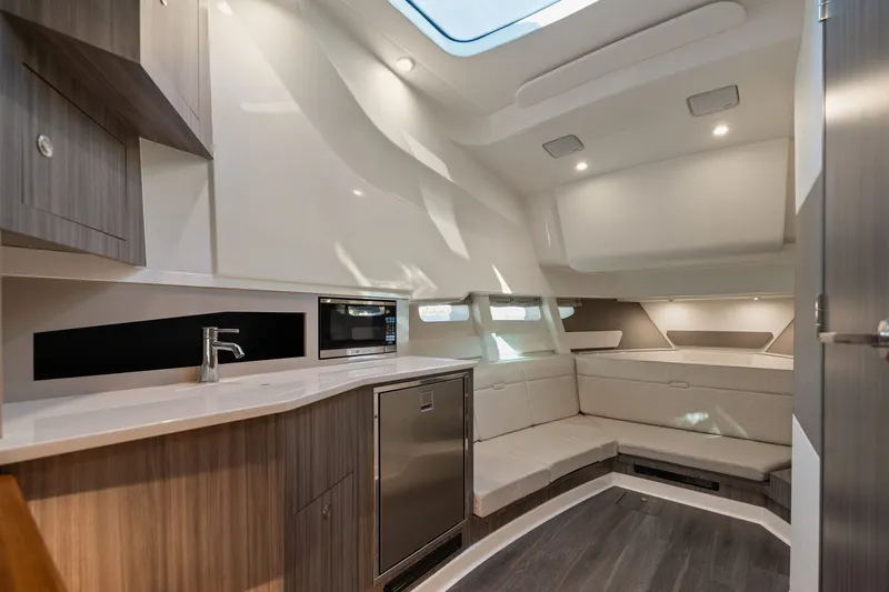  Yacht Photos Pics Luxurious interior of 2023 Sea Ray 370 Sundancer yacht with modern kitchen and seating area.