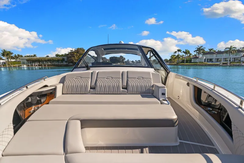  Yacht Photos Pics 2023 Sea Ray 370 Sundancer luxury boat interior with plush seating, docked by a scenic waterfront.