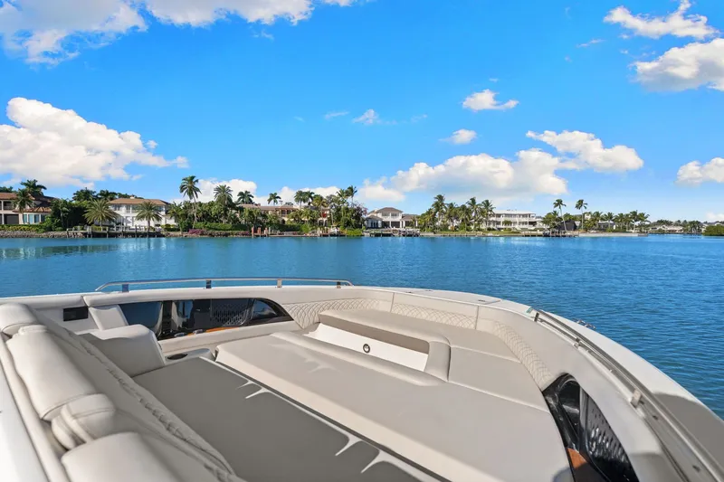  Yacht Photos Pics 2023 Sea Ray 370 Sundancer on tranquil water with palm trees and blue sky.