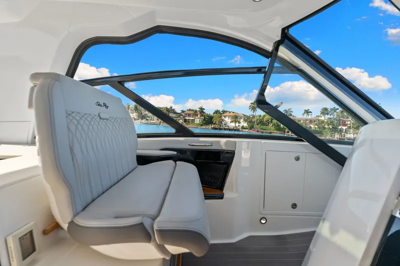  Yacht Photos Pics 2023 Sea Ray 370 Sundancer interior with luxurious seating and scenic waterfront view.