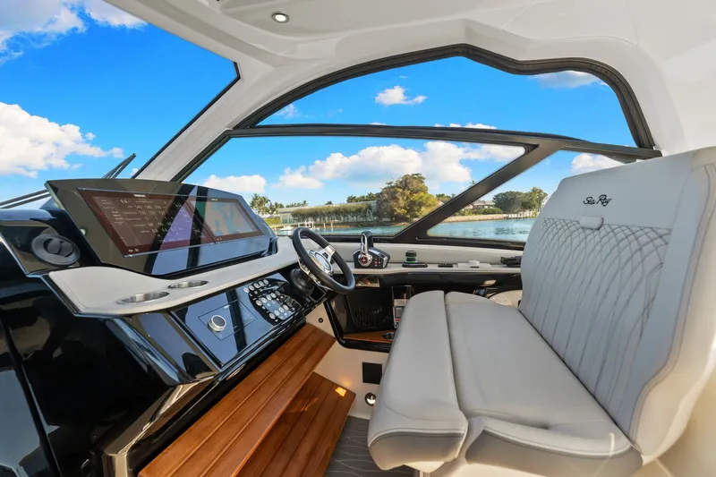  Yacht Photos Pics 2023 Sea Ray 370 Sundancer helm with modern controls and luxurious seating, overlooking serene waters.