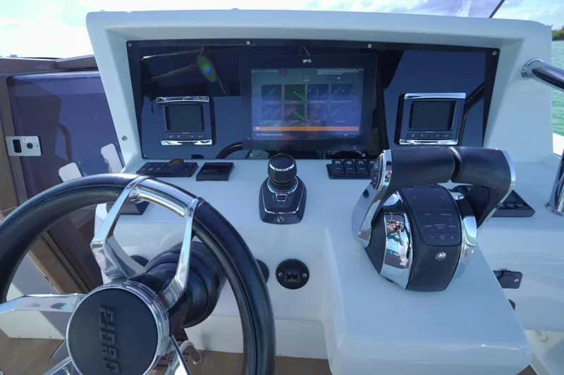  Yacht Photos Pics Control panel of 2018 Fjord 36 Xpress boat with steering wheel and navigation screens.