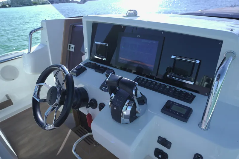  Yacht Photos Pics Control panel of a 2018 Fjord 36 Xpress boat with steering wheel and navigation screens.