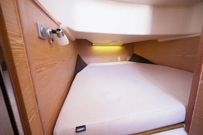  Yacht Photos Pics Cozy cabin interior of 2018 Fjord 36 Xpress yacht with wooden walls and soft lighting.