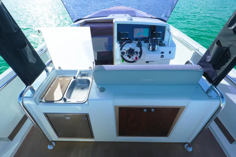  Yacht Photos Pics Helm and kitchenette area of 2018 Fjord 36 Xpress boat on water.