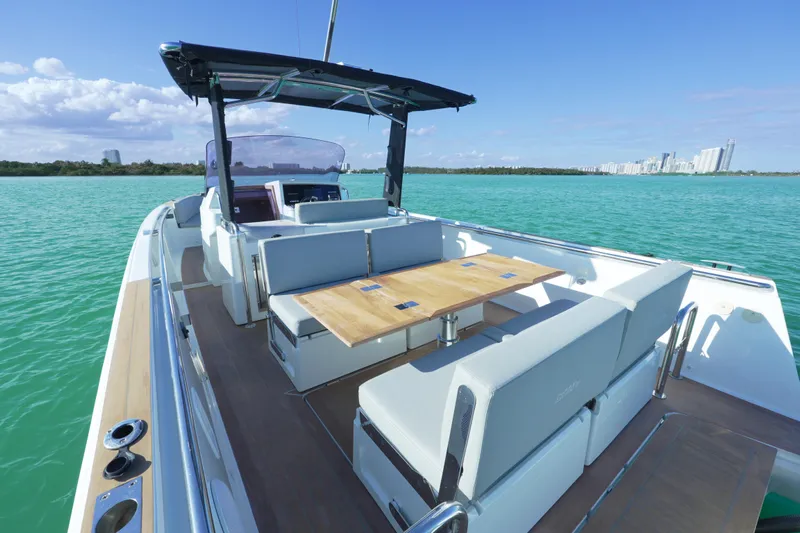 Yacht Photos Pics 2018 Fjord 36 Xpress boat with spacious seating, cruising on turquoise waters near a city skyline.
