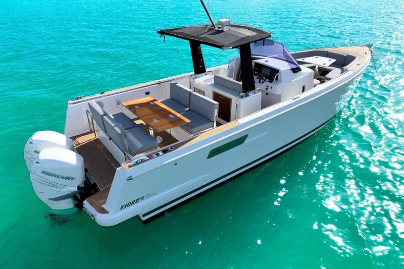  Yacht Photos Pics 2018 Fjord 36 Xpress boat on turquoise water, featuring sleek design and twin Mercury engines.