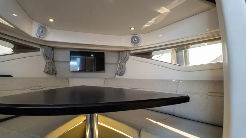 At Times Yacht Photos Pics Interior of 2019 Sea Ray Sundancer 320 yacht with seating, table, and TV.
