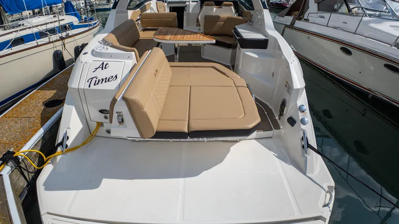 At Times Yacht Photos Pics 2019 Sea Ray Sundancer 320 yacht with tan seating and wooden table, docked at marina.
