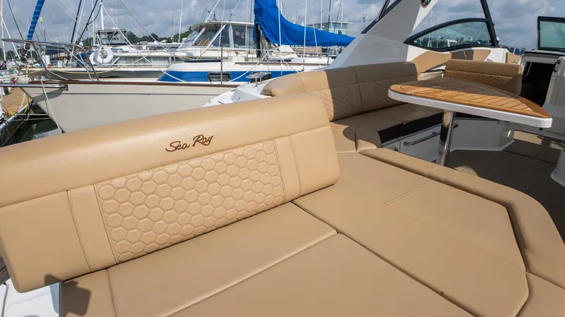At Times Yacht Photos Pics 2019 Sea Ray Sundancer 320 yacht with tan seating and wooden table in marina setting.