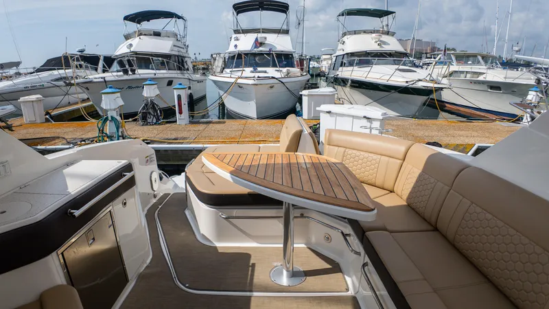 At Times Yacht Photos Pics 2019 Sea Ray Sundancer 320 yacht interior with elegant seating and table at marina.