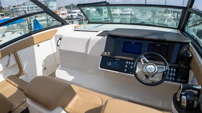 At Times Yacht Photos Pics 2019 Sea Ray Sundancer 320 helm with modern controls and luxurious seating at a marina.