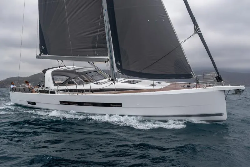  Yacht Photos Pics 2025 Jeanneau Yachts 55 sailing on open water with sleek design and dark sails.