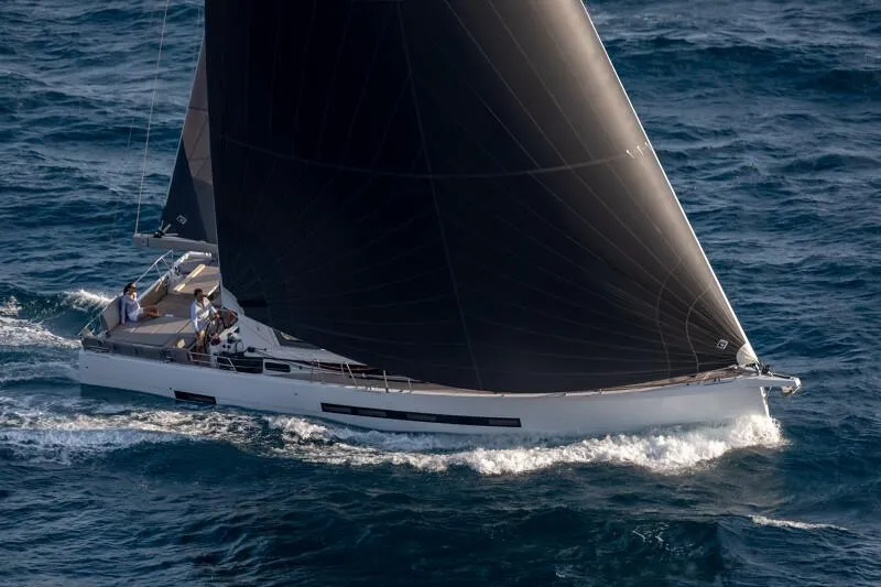  Yacht Photos Pics 2025 Jeanneau Yachts 55 sailing on open sea with black sails.