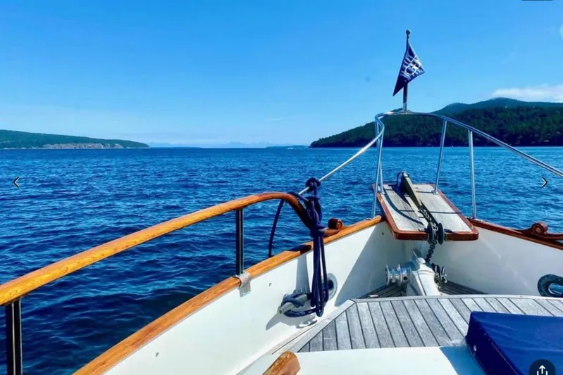 Yonder Yacht Photos Pics Bow view of 1984 Grand Banks 36 Classic yacht cruising on a clear blue sea.