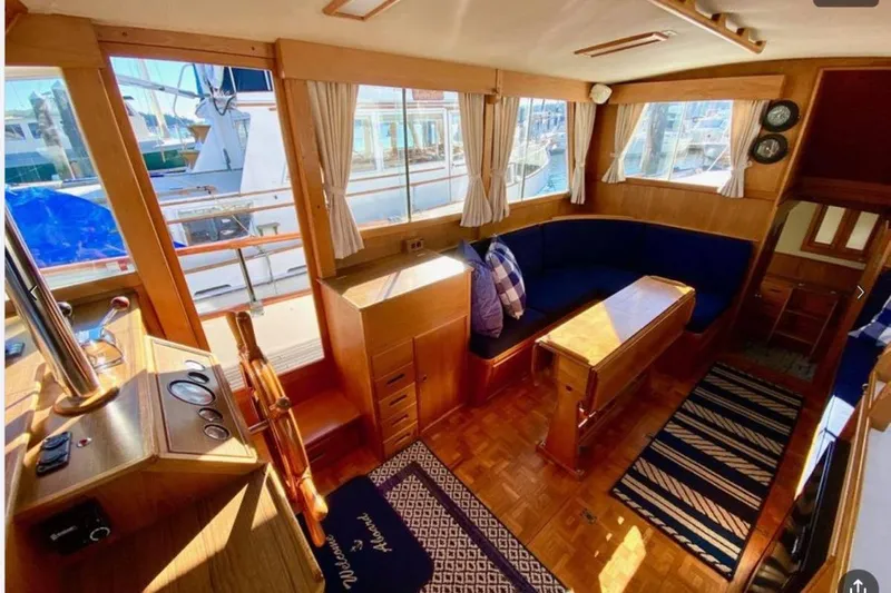 Yonder Yacht Photos Pics Interior of 1984 Grand Banks 36 Classic yacht with wooden furnishings and blue seating.