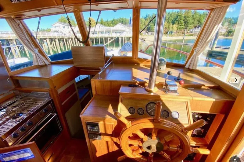 Yonder Yacht Photos Pics 1984 Grand Banks 36 Classic yacht interior with wooden helm and kitchen area.
