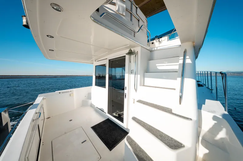  Yacht Photos Pics 2003 Navigator 3900 yacht deck with stairs, overlooking calm blue waters.